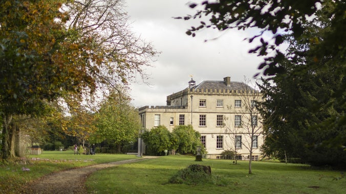 Newark Park house in the background with trees in the foreground